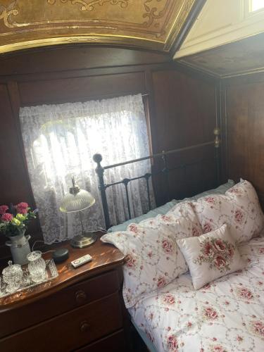 普里茅斯Vintage Showman's Wagon For Two Close to Beach的一间卧室配有一张带桌子和窗户的床