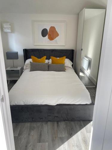 WateringburyCarriage Lodge - Stunning Apartment with parking的卧室配有一张带黄色枕头的大型白色床。