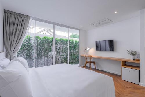 合艾Casa 33 Hatyai的白色的卧室设有床和窗户