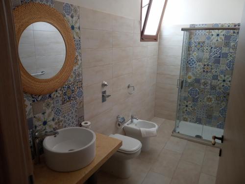 伯吉维奇Isole Dello Stagnone Apartaments的一间带卫生间、水槽和镜子的浴室