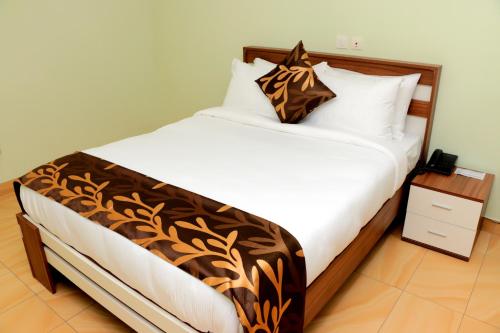 阿比让HOTEL LAVAL的一间卧室配有一张大床,配有棕色和白色的毯子