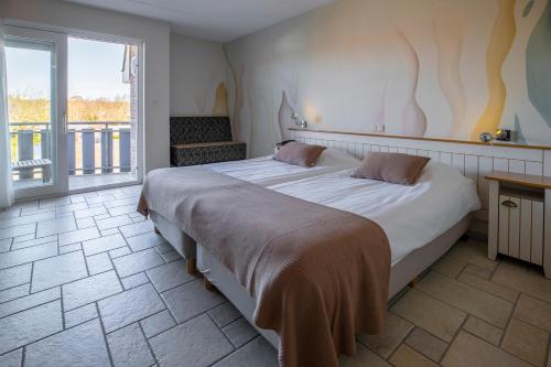 德科赫特塞尔霍夫酒店的一间带大床的卧室和一个阳台