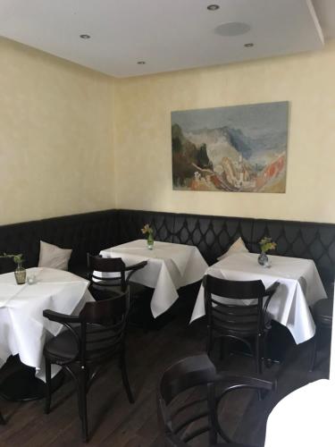 特拉本特拉巴赫Augusta Trarbach的一间带桌椅的用餐室和一幅画