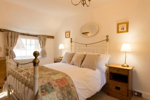 萨弗伦沃尔登Miller Cottage a luxury 1550's cottage in the Historic centre of Saffron Walden的卧室配有白色的床和窗户。