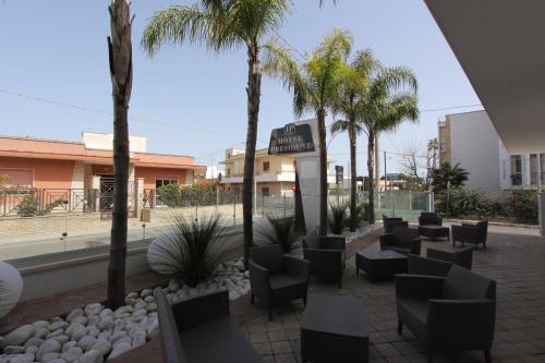 切萨雷奥港Hotel Presidente的商场内带椅子和棕榈树的庭院