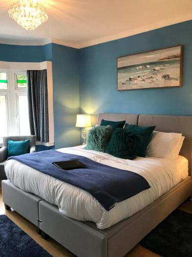 桑当The Drey的一间卧室配有一张带蓝色墙壁的大床