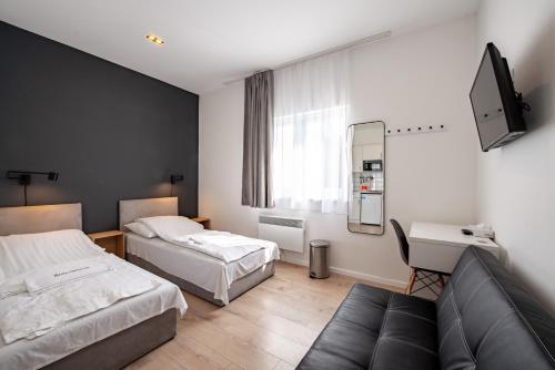 布达佩斯Chesscom Apartments的酒店客房,设有两张床和一张沙发