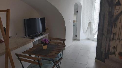 普蒂尼亚诺Il Vicolo b&b的客厅配有小桌子和电视