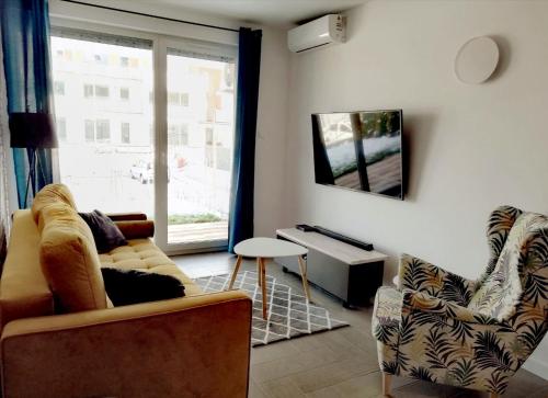 斯图托沃Apartament Sand&Blue的带沙发和椅子的客厅以及窗户。