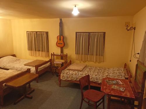 KremnaBrvnara Ljubičica的一间设有两张床和吉他的房间