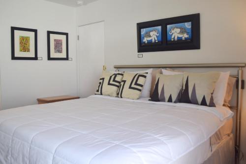 棕榈泉西网球俱乐部艺术民宿的卧室配有带枕头的大型白色床