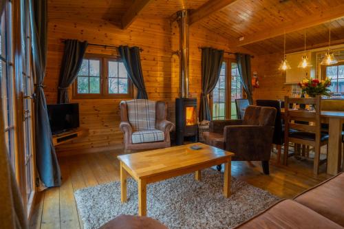 海布里奇Wall Eden Farm - Luxury Log Cabins and Glamping的小屋内带桌椅的客厅
