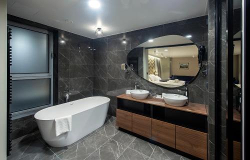 瓦拉日丁图瑞斯特酒店的一间带两个盥洗盆和大镜子的浴室