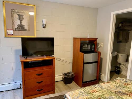 WrightstownHill Top Motel的一间卧室配有带电视的梳妆台和床