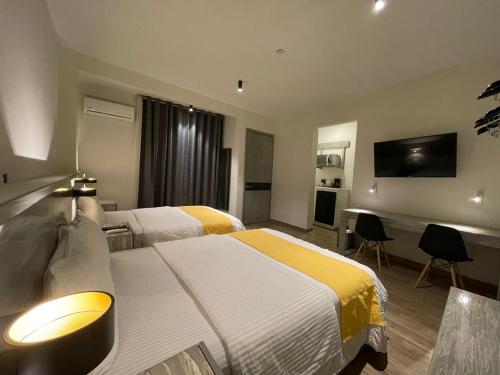 Chilpancingo Capital Suites的酒店客房设有两张床和一台平面电视。