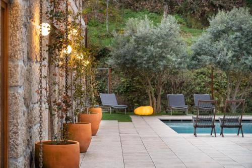 塞亚Casas Da Lapa, Nature & Spa Hotel的一个带椅子的庭院和一个游泳池