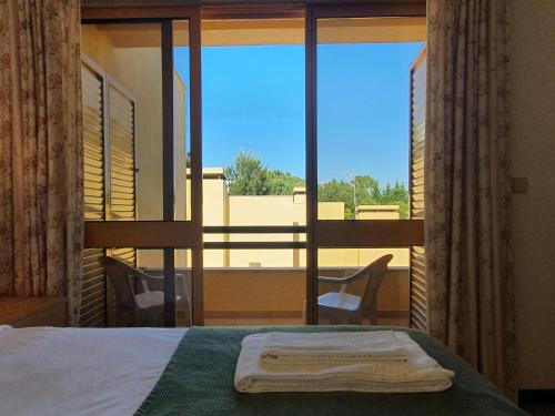 特罗亚Tróia Beach Villa的一间卧室设有一张床和一个美景窗户。