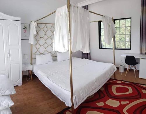 加拉班Summer Stay的一间卧室配有天蓬床和红色地毯。