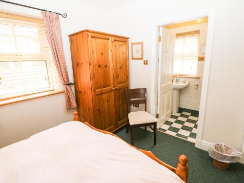 SkahanaghLis-Ardagh Cottage 1的一间卧室配有一张床,浴室设有水槽