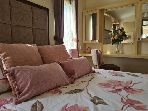 彭布罗克郡Beautiful 2 bedroom caravan, holiday park Tenby的一间卧室,床上有粉红色的鲜花