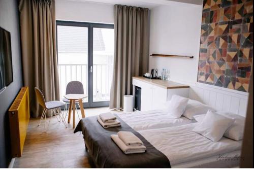 波别罗沃Na Fali Restaurant&Apartaments的一间卧室配有一张大床和两条毛巾
