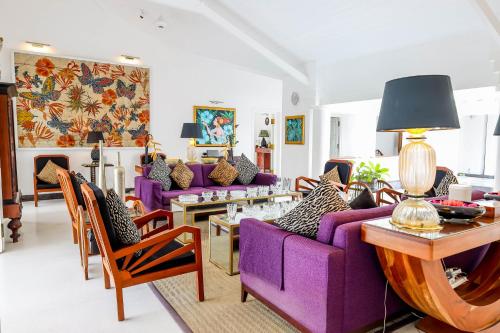 康提The Flame Tree Estate & Hotel的客厅配有紫色家具和紫色沙发