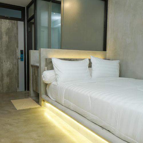 雅加达Dparagon Menteng Jakarta的卧室配有一张带镜子的白色大床