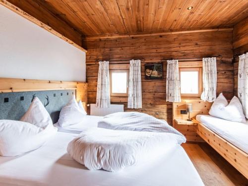 菲根贝格Charming holiday home in Fügenberg with sauna的木墙客房的两张床