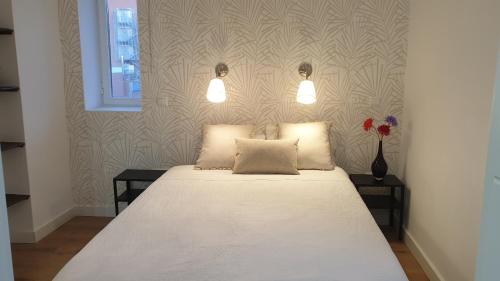 托莱多Azabache的一间卧室配有白色的床、两张桌子和两个灯