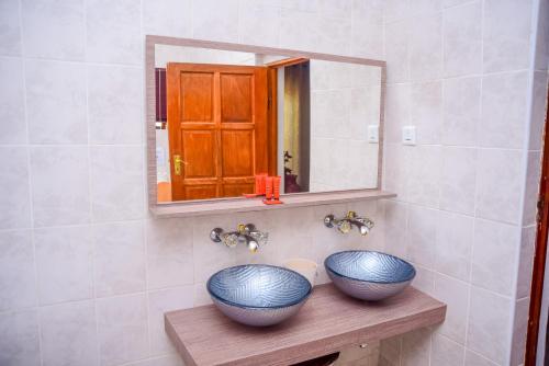 哈博罗内African Home Hotel的浴室木架上两个蓝色碗