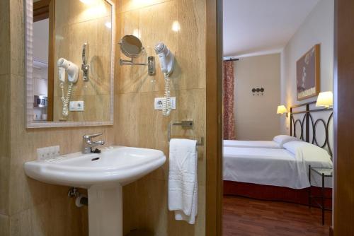 塞维利亚穆里略公寓的一间带水槽的浴室和一间带一张床的卧室