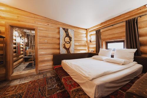 卡拉甘达Inn OZZ的卧室配有一张床铺,位于带木墙的房间内