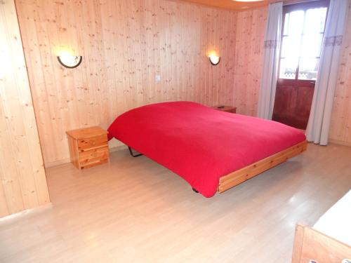 Troistorrents海尔维提亚住宿加早餐旅馆的一间卧室配有红色的床和红色毯子