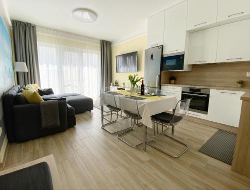 凯斯特海伊NEST2 Apartments的厨房以及带桌椅的起居室。