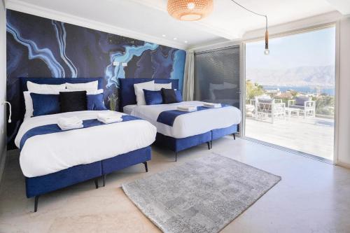 埃拉特YalaRent Villa Enorma with Private Pool的一间卧室配有两张蓝色和白色的床