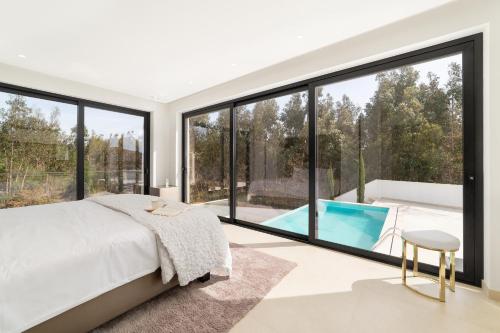 圣马蒂纽·杜·波特Villa Floresta - By SCH的一间带大窗户和游泳池的卧室