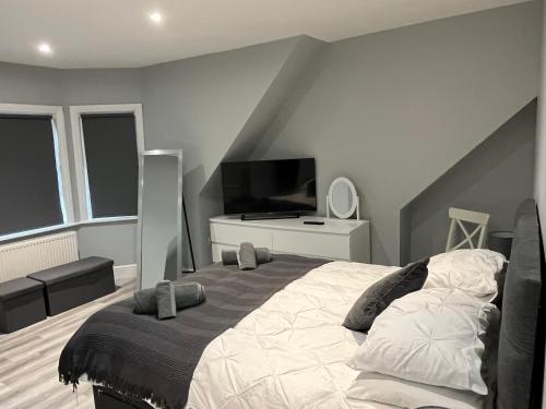 伯恩茅斯Entire spacious 4 bedroom apartment in Bournemouth的一间卧室配有一张大床和电视