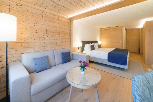 格施塔德Gstaaderhof - Active & Relax Hotel的客厅配有沙发和1张床