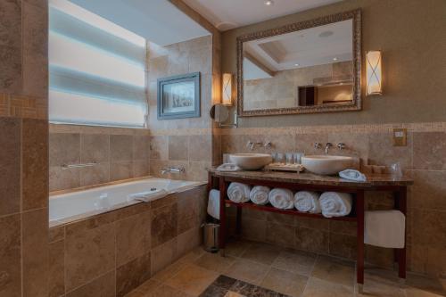 Fota Island福塔岛Spa酒店的浴室设有2个水槽、浴缸和镜子