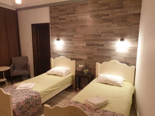 巴克乌Bizant Boutique的一间卧室设有两张床和木墙