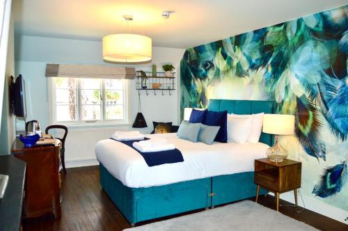 彼得斯菲尔德The Nest Hotel & Restaurant的卧室配有一张蓝色的床,墙上挂着一幅画