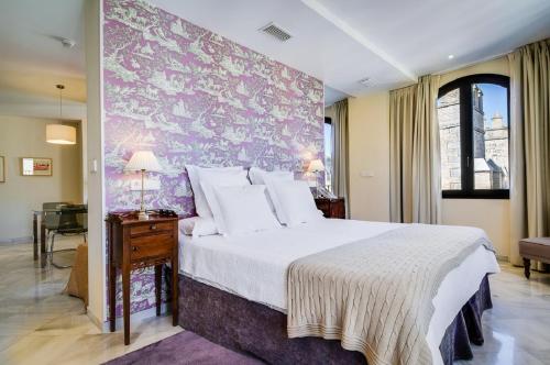 塞维利亚Suites Murillo Alcázar的一间卧室配有一张大床和紫色墙壁