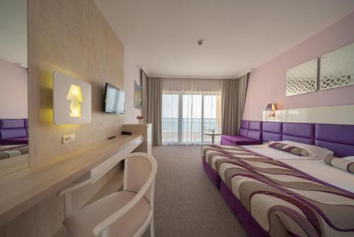 金沙GRIFID Arabella Hotel - Ultra All inclusive & Aquapark的酒店客房配有两张紫色床铺。