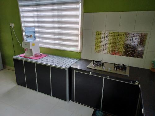 加央Homestay Dalia, Beseri, Perlis的厨房配有柜台、水槽和窗户