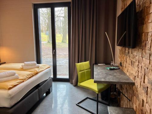 什未林Zweirad Hotel Lenne的一间卧室配有一张床、一张书桌和一个窗户。