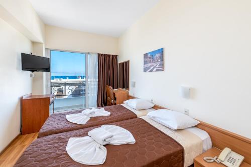 罗德镇赫耳墨斯酒店的酒店客房设有两张床和电视。