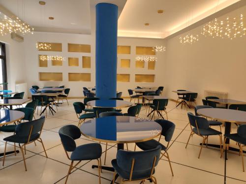 韦内雷港格拉兹酒店的配有桌椅的房间和蓝色的柱子