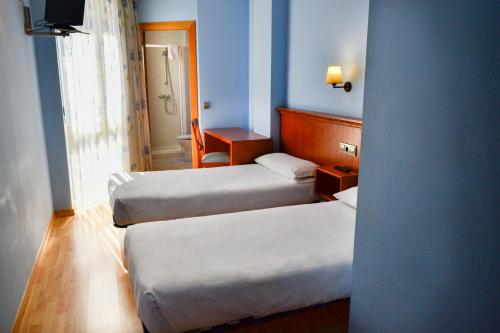 拉瓦涅萨Alda Vía de la Plata Rooms的酒店客房,配有两张床和椅子