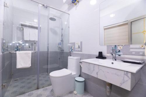 下龙湾Green bay hotel Ha Long的浴室配有卫生间、盥洗盆和淋浴。