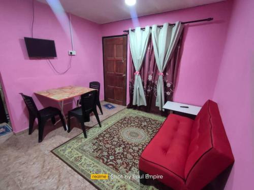 加央Pink Homestay D'Perlis的客厅配有红色的沙发和桌子